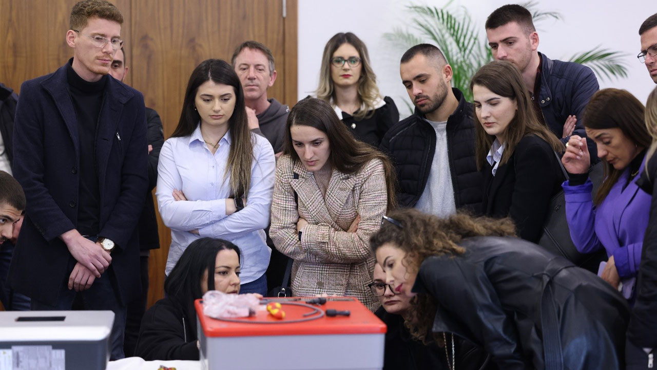 Solar engineers huddle together for a demonstration at a two-week training intended to certify participants in solar fundamentals and practical skills