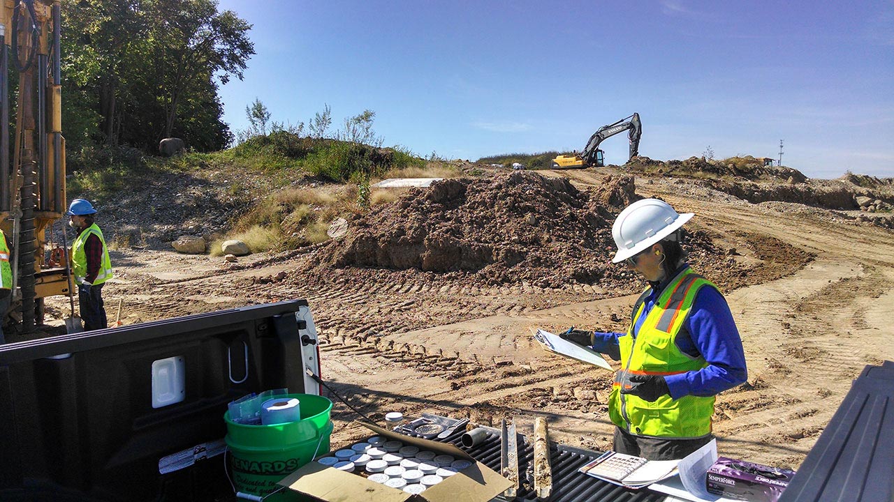 People standing at a site where soil boring drilling is being conducted in Glacier Ridge Landfill, Wisconsin