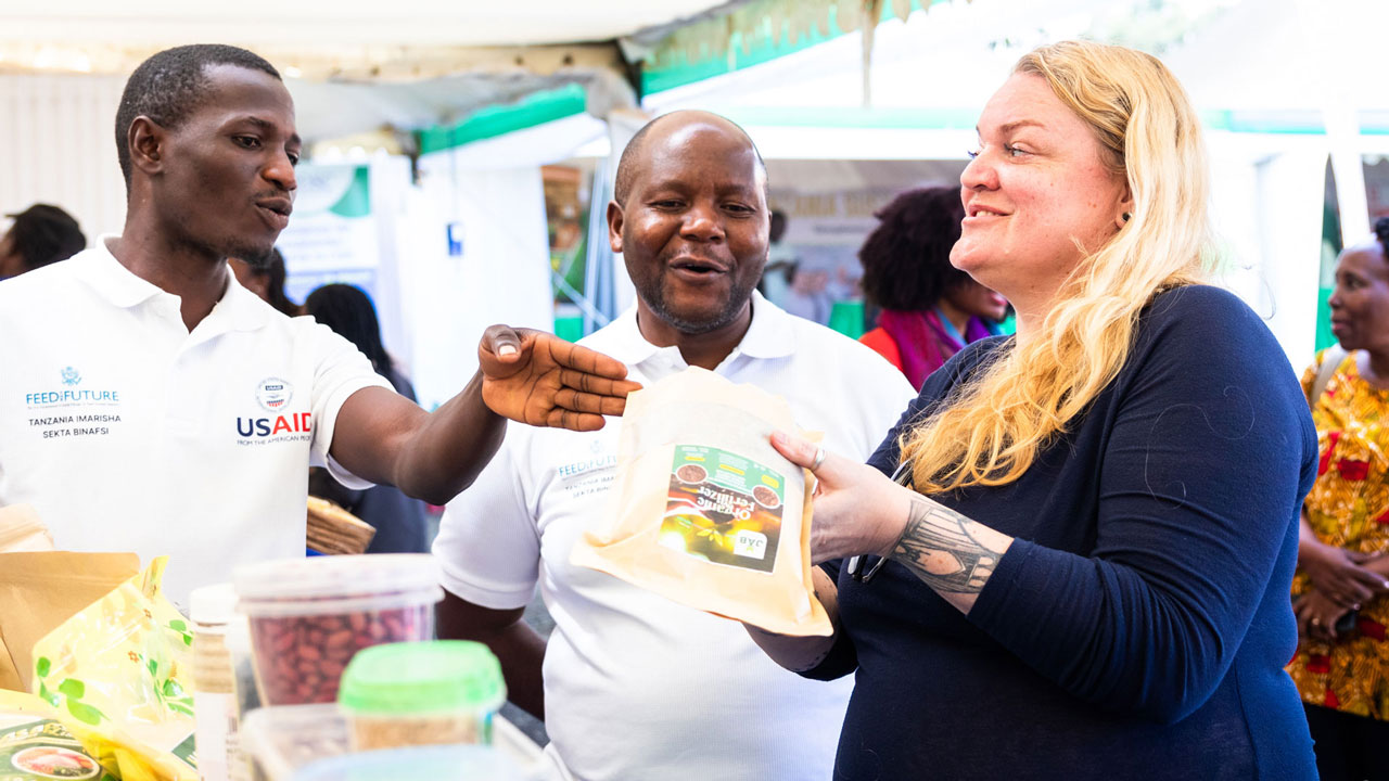 A youth enterprise beneficiary of Feed the Future Tanzania Private Sector Strengthening Activity, demonstrates his organic fertilizer