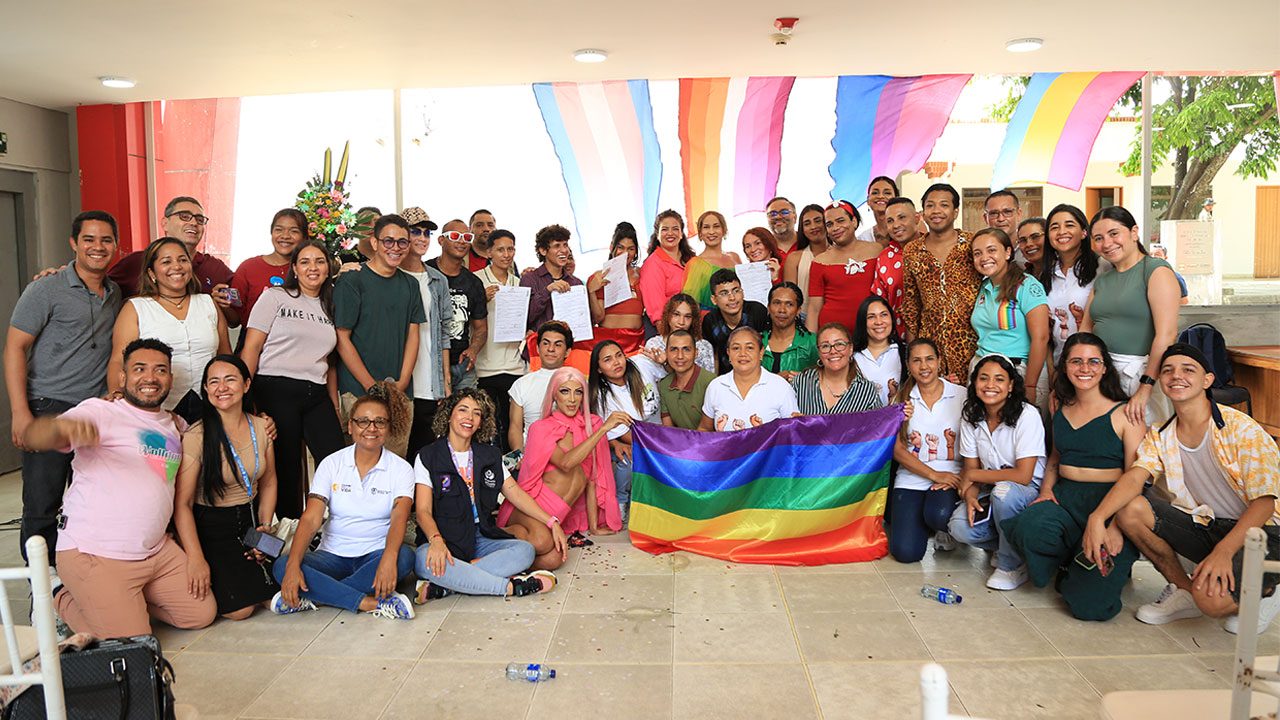 Group photo of the Generating Equity project team with people in the front row holding a rainbow flag