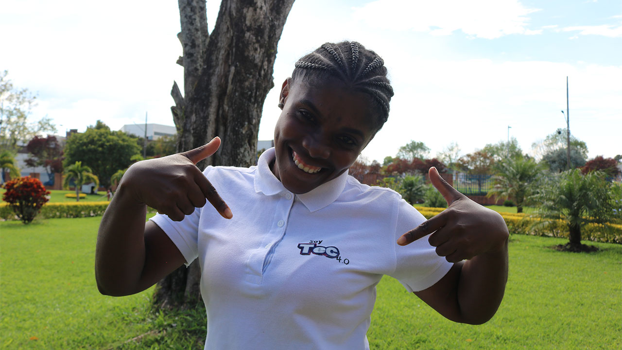 A smiling woman training to be a gas technician through the “Soy Tec” program in Southwest Colombia points to herself