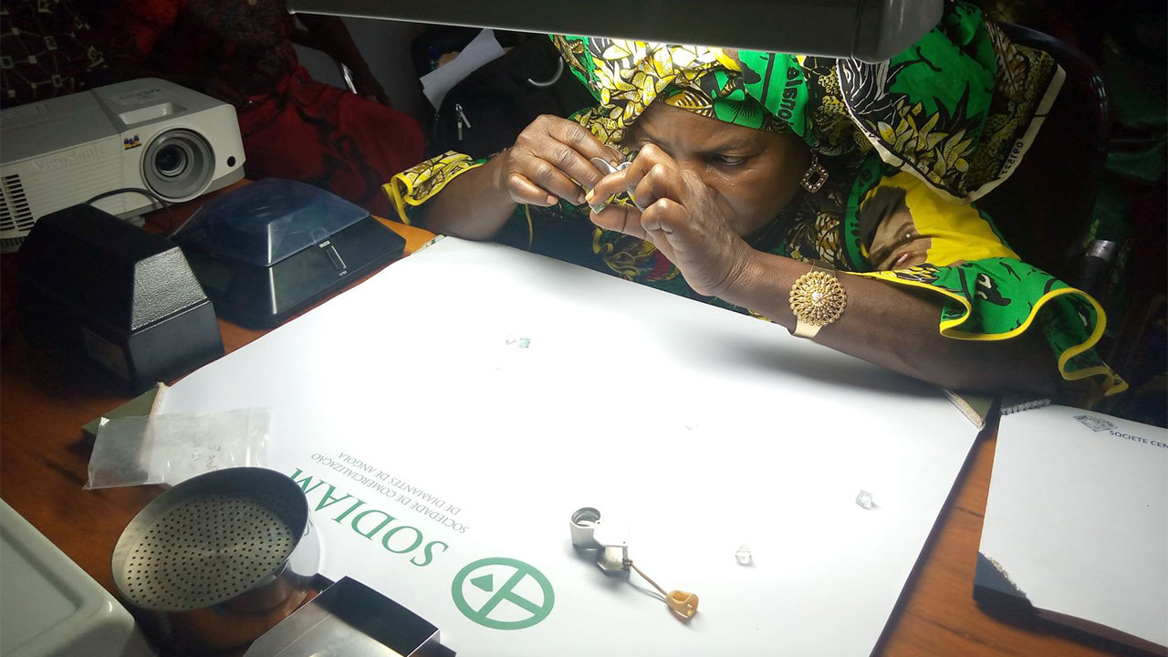 A woman studies a diamond to assess its value