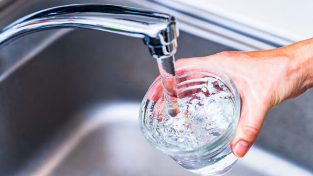 A glass of water being filled in a sink