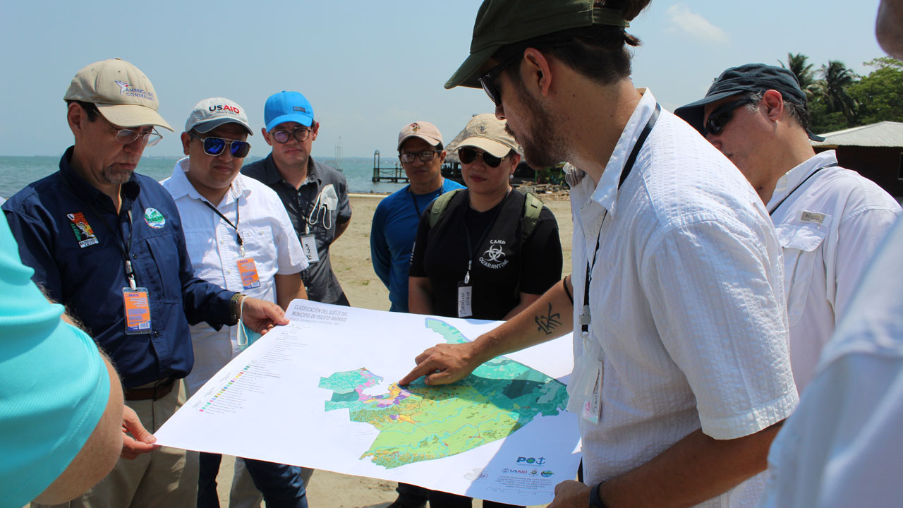 A small group of people, including municipal officials, review a land-use planning map